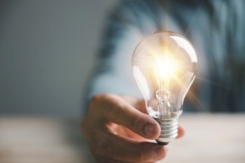 Conceptual image of a man with a light bulb, illustrating the power of creative thinking, innovation, and intelligent solutions in the business world. This idea radiates success and creativity.