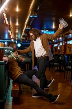 Unhappy furious friends fighting at pub. Soccer football fans misunderstanding. Fury guy trying to hit mate with empty beer glass. Unhappy furious friends fighting at pub