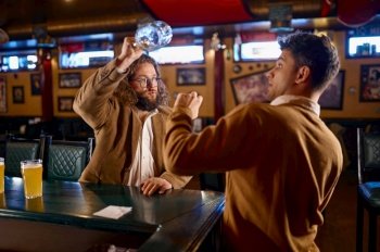 Unhappy furious men fighting at pub. Soccer football fans misunderstanding. Fury guy trying to hit mate with empty beer glass. Unhappy furious men fighting at pub