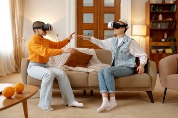 Young lesbian woman couple wearing vr goggles playing video game with experience virtual reality at home. LGBT, friendship and happy pastime together concept. Young lesbian woman couple wearing vr goggles playing video game