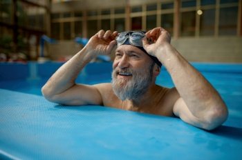 Healthy senior man swimming in indoor pool enjoying sportive lifestyle and active retirement. Healthy senior man swimming in indoor pool enjoying sportive lifestyle