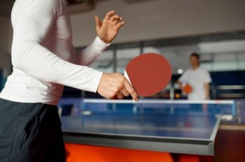 Game match participants playing table tennis. Selective focus on racket in hand of male competitor, view from back. Concept of leisure activity and sport. Game match participants playing table tennis selective focus view from back