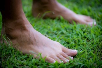 Practicing grounding, barefoot female feet touching the ground.. Grounding therapy