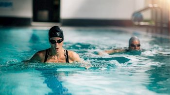 Women Swimming Together in Indoor Swimming Pool.