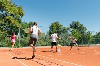 Energetic group participating in a high-energy cardio tennis training session, combining fitness and tennis skills. Cardio tennis training class