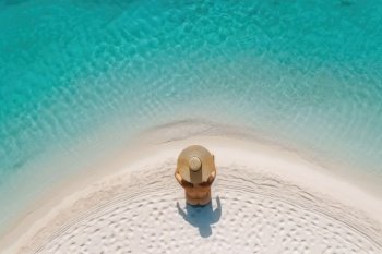 Aerial view of slim woman sunbathing on beach in Maldives. Generative AI
