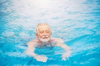 Caucasian healthy elder swimming at the swimming pool for relax in summer holiday activity