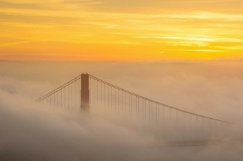 Golden Gate Bridge with low fog in USA at sunrise