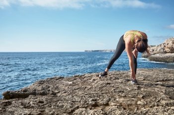 Latin woman, middle-aged, wearing sportswear, training, doing physical exercises, plank, sit-ups, climber’s step, burning calories, keeping fit, outdoors by the sea, wearing headphones, smart watch