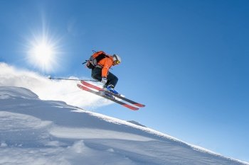 A young skier at speed flying through the sky