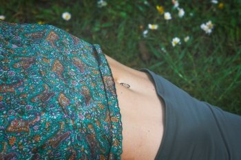 Detail of navel piercing on a girl drawn in the lawn