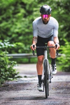 A sporty man on a racing bike on a narrow abandoned road