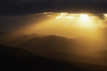 Golden crepuscular rays spill out and illuminate the mountains and valleys of Shenandoah National Park.