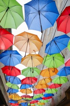 Umbrellas exhibition, street decorated. the sky is filled with colorful umbrellas. Many colorful umbrellas against the sky in city settings. Color background