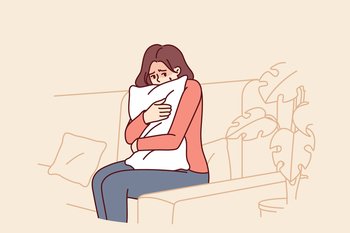 Frightened woman hugging pillow sitting on couch feeling fear and depressed psychological state. Frightened teen girl is afraid to be alone and sad because of breaking up with boyfriend. Frightened woman hugging pillow sitting on couch feeling fear and depressed psychological state