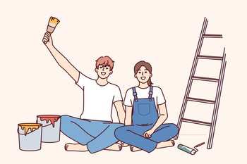 Couple makes repairs in apartment with own hands and sits on floor near ladder and buckets of paint for painting walls. Cheerful man and woman rejoice at opportunity to make diy repairs in room. Couple makes repairs in apartment with own hands and sits on floor near ladder and buckets of paint