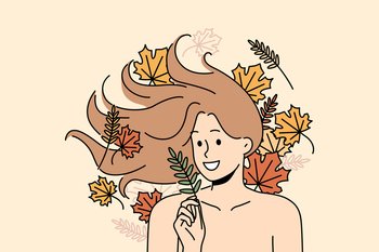 Woman with long flowing hair lies among autumn leaves and smiles rejoicing at onset of september. Woman with bare shoulders for advertising cosmetics or shampoo made on basis of herbs and plants. Woman with long flowing hair lies among autumn leaves and smiles rejoicing at onset of september