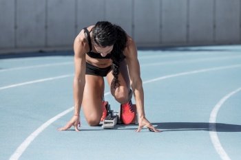 athlete woman in starting position on running track