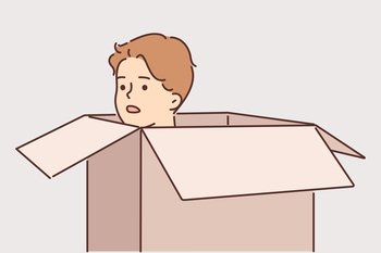 Frightened man hides in carton box and looks out to inspect area around. Frightened young guy with embarrassment hiding in cardboard package trying to avoid meeting offender or unpleasant person. Frightened man hides in carton box trying to avoid meeting offender or unpleasant person