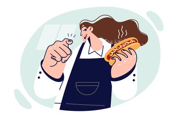 Woman chef of fast food restaurant holding hot dog and pointing finger at screen offering delicious lunch. Girl in apron works in fast food cafe and with smile lures hungry customers. Woman chef of fast food restaurant holding hot dog and pointing finger at screen offering lunch