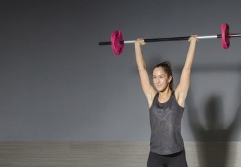 Sportswoman in gym exercising muscles