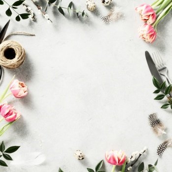 Easter background with  spring flowers and cutlery on light grey background top view flat lay copy space square composition