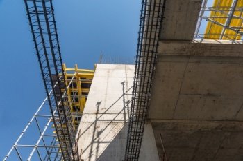 metal concrete structures of the building under construction. scaffolding and supports on a sky background. bottom view. metal concrete structures
