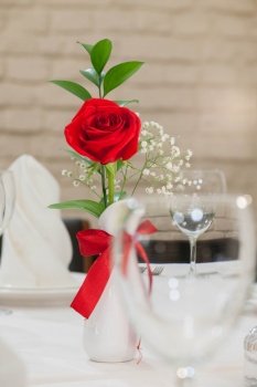 rose flowers in a vase on a celebratory table on a light background. flowers in a vase on a festive table