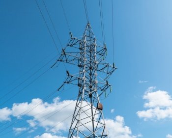 high voltage tower against the blue sky and clouds. post electric, insulated