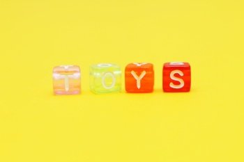 Word toys with colorful cubes of beads on a yellow background. Word toys with colorful cubes of beads on yellow