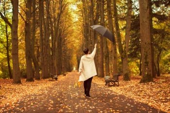 woman with an umbrella walks in autumn park