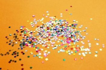 multicolor sparkles on orange background. Festive backdrop for your projects. multicolor sparkles on a orange background. Festive backdrop for your projects.