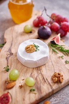 Camembert or brie cheese on wooden cutting board at domestic kitchen.. Camembert or brie cheese on wooden cutting board at domestic kitchen