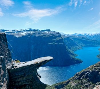 The summer view of Trolltunga (The Troll’s tongue) in Odda ( Ringedalsvatnet lake, Norway) and man on rocks edge.