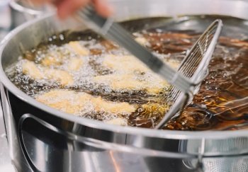 Preparation of fried churros with sugar typical of Spain