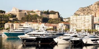 Monte Carlo, Monaco - August 2022: Port Hercule with luxury yachts,  boats, and scenery skyline
