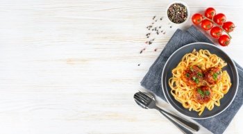 Homemade spaghetti with tomato sauce meatballs and spices served on white background. Tasty cooked pasta and meat balls made with minced beef, food ingredients. Top View, Flat lay, banner, copy space