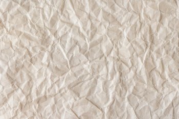 Recycled crumpled beige paper texture background. Wrinkled and creased abstract backdrop, wallpaper with copy space, top view.