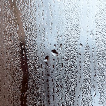Texture of a drop of rain on a glass wet transparent background. Toned in grey color