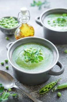 Fresh green pea soup bowl on gray concrete background