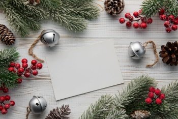 Christmas background with fir tree, post card and decor on white wooden background. Top view with copy space