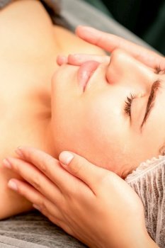 Face massage. Beautiful caucasian young white woman having a facial massage with closed eyes in a spa salon. Face massage. Beautiful caucasian young white woman having a facial massage with closed eyes in a spa salon.