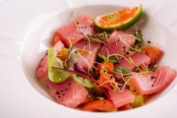 Smoked salmon salad in white bowl close up
