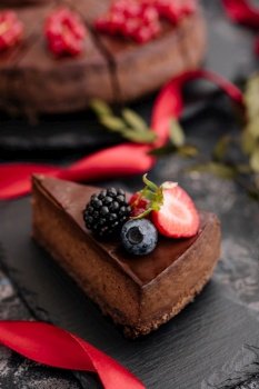 Delicious chocolate cake decorated with fresh berries on wooden table
