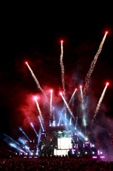 salute and fireworks on a music stage with spotlights at night