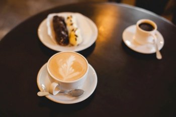 close up a mug of fragrant cappuccino and a sweet dessert on the table
