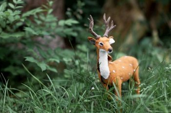 a beautiful little figure of a spotted deer in the grass
