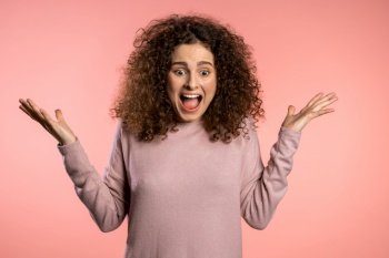 Close up of young scared curly girl shouting isolated over pink background. Stressed and depressed woman. Close up of young scared curly girl shouting isolated over pink background. Stressed and depressed woman.