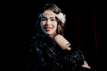 Amazing portrait of brunette woman dressed in style of last century on velours background. Roaring twenties, retro, party, fashion concept. High quality photo. Amazing portrait of brunette woman dressed in style of last century on velours background. Roaring twenties, retro, party, fashion concept