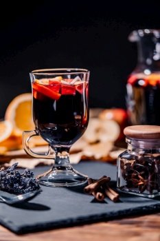 Still life - mulled wine, hot red wine with spices in glass among fruits. Scented cozy Christmas celebration, fragrant punch concept. High quality. Still life - mulled wine, hot red wine with spices in glass. Scented Christmas